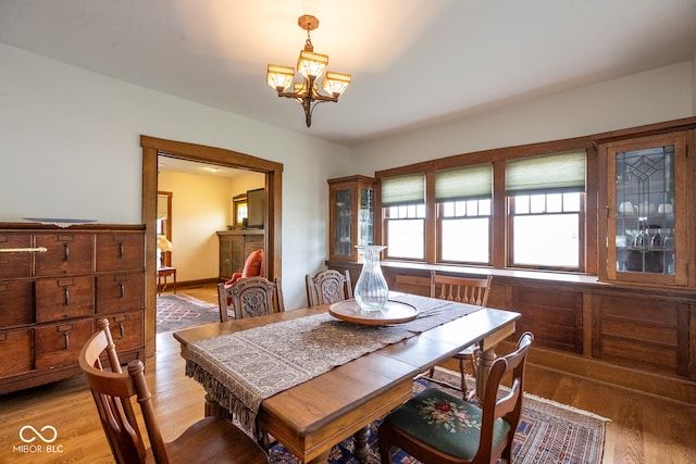 dining space featuring hardwood / wood-style flooring and a chandelier