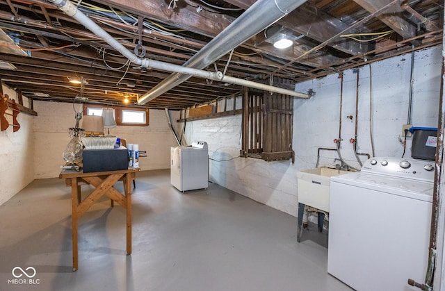 basement with washing machine and clothes dryer and a sink