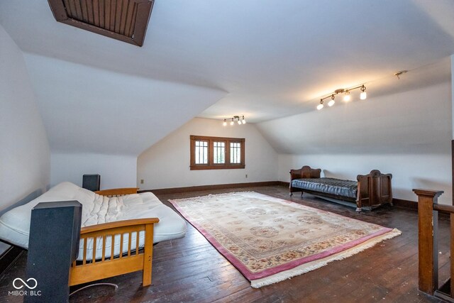 bedroom with wood-type flooring, vaulted ceiling, and baseboards