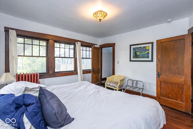 bedroom featuring radiator, baseboards, and dark wood-style floors
