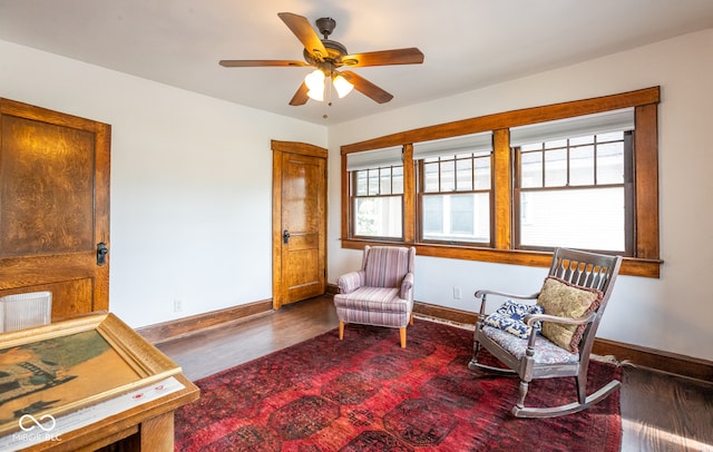 living area with dark hardwood / wood-style flooring, ceiling fan, and plenty of natural light