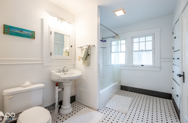 bathroom with tiled shower / bath, toilet, and tile patterned flooring