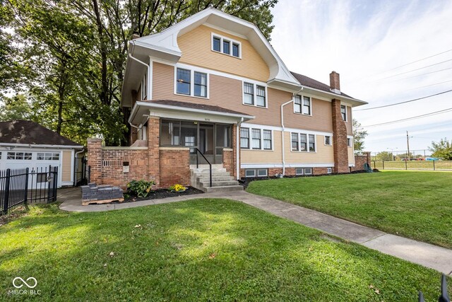 1457 Fairfield Ave, Indianapolis, IN 46205 - american foursquare style home featuring a chimney, fence, a front lawn, an outdoor structure, and a detached garage