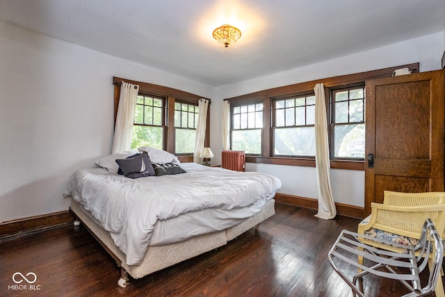 bedroom with dark wood-type flooring and multiple windows