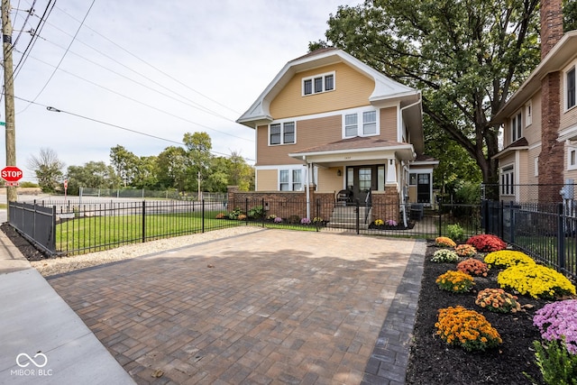 traditional style home with a gate, a fenced front yard, and covered porch
