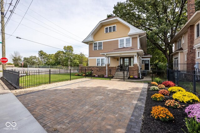 1457 Fairfield Ave, Indianapolis, IN 46205 - traditional style home with a gate, a fenced front yard, and covered porch