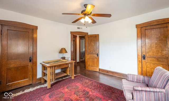 living area with ceiling fan and dark hardwood / wood-style flooring