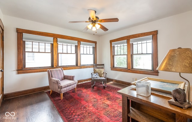 living area with dark wood-type flooring and ceiling fan