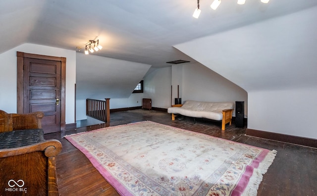 bedroom featuring lofted ceiling, wood finished floors, and baseboards