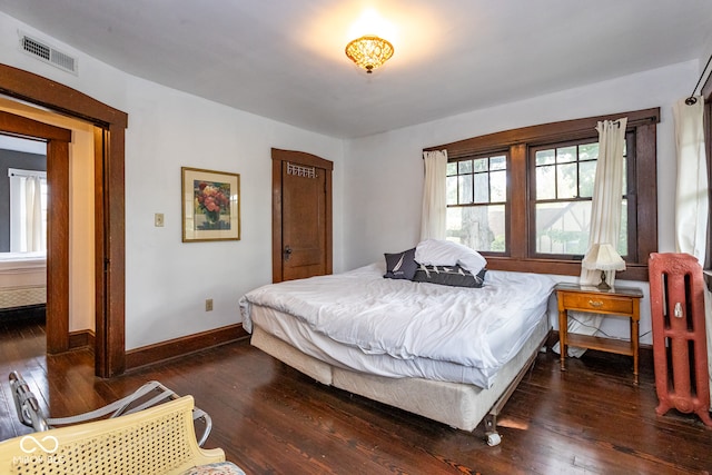 bedroom with dark hardwood / wood-style floors