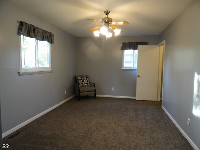 unfurnished room featuring dark colored carpet and ceiling fan