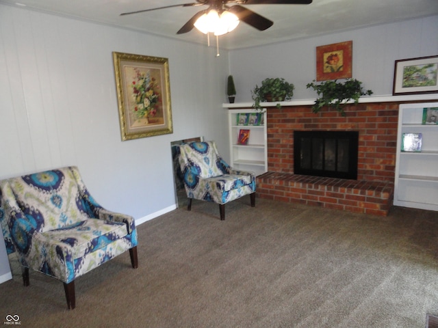 sitting room featuring a brick fireplace, ornamental molding, carpet, and ceiling fan