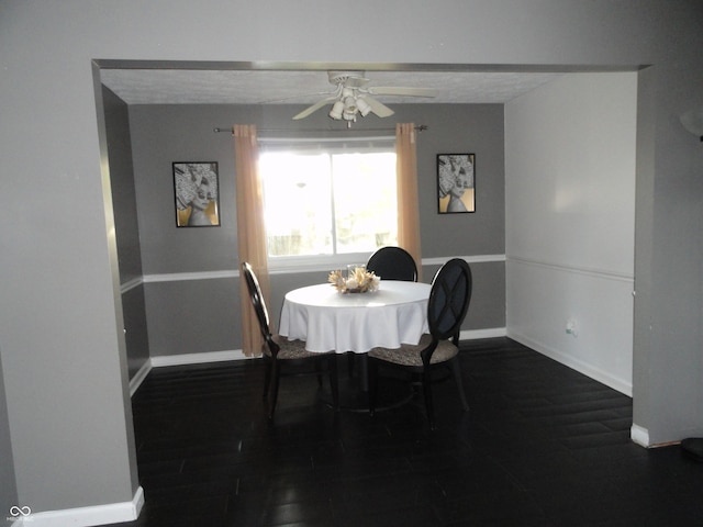 dining space featuring a textured ceiling, ceiling fan, and dark wood-type flooring