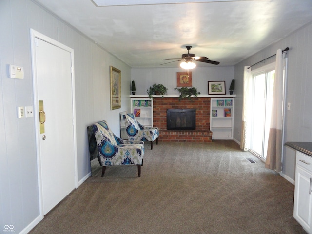 unfurnished living room with dark carpet, a brick fireplace, and ceiling fan