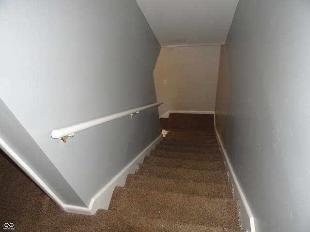 stairway with carpet and vaulted ceiling