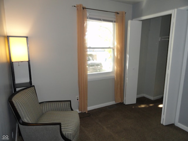 sitting room featuring dark carpet