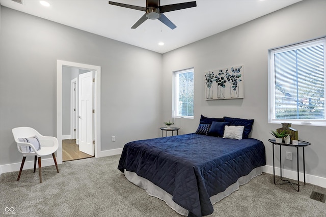 carpeted bedroom with multiple windows and ceiling fan