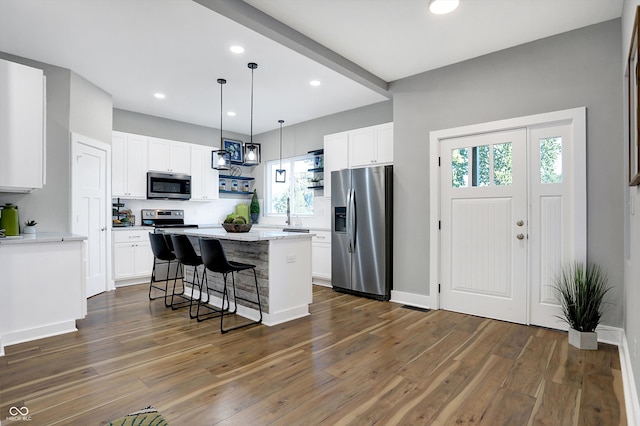 kitchen with stainless steel appliances, a center island, and white cabinetry