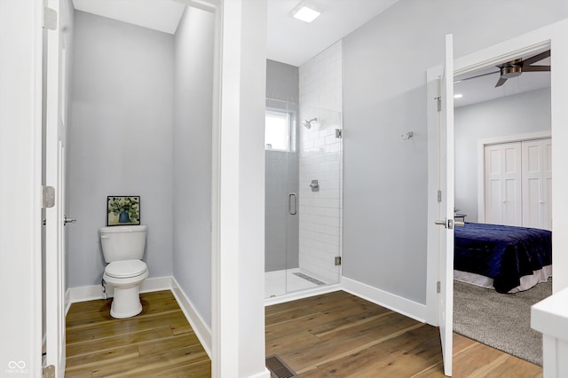 bathroom with walk in shower, ceiling fan, hardwood / wood-style flooring, and toilet