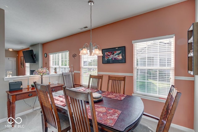 dining area featuring carpet floors and an inviting chandelier