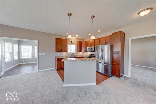 kitchen with a kitchen island, pendant lighting, light carpet, brown cabinets, and appliances with stainless steel finishes