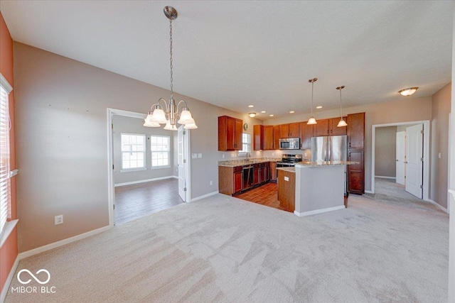 kitchen featuring open floor plan, light colored carpet, brown cabinetry, a notable chandelier, and stainless steel appliances