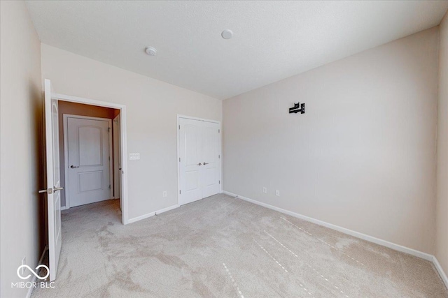 unfurnished bedroom featuring carpet and baseboards