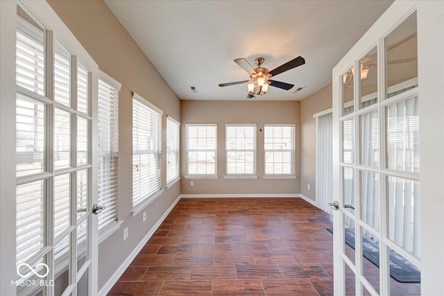 unfurnished sunroom with visible vents, french doors, and ceiling fan