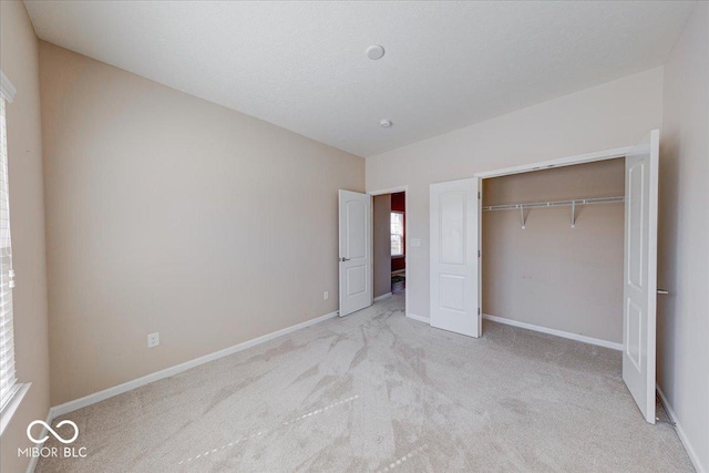 unfurnished bedroom with a closet, carpet flooring, and baseboards