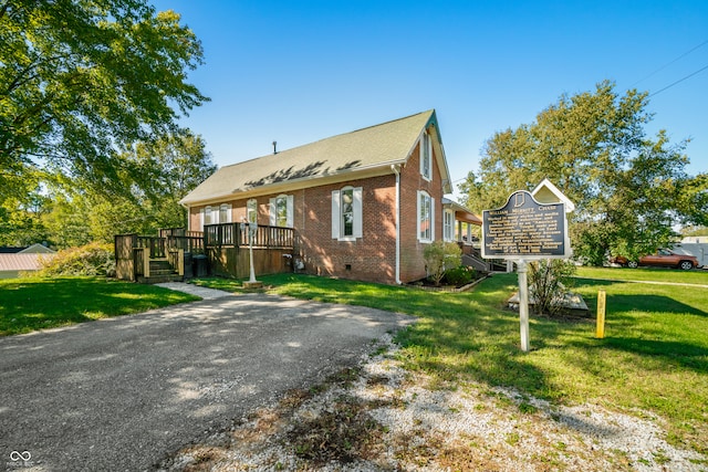 view of front of house with a wooden deck and a front yard