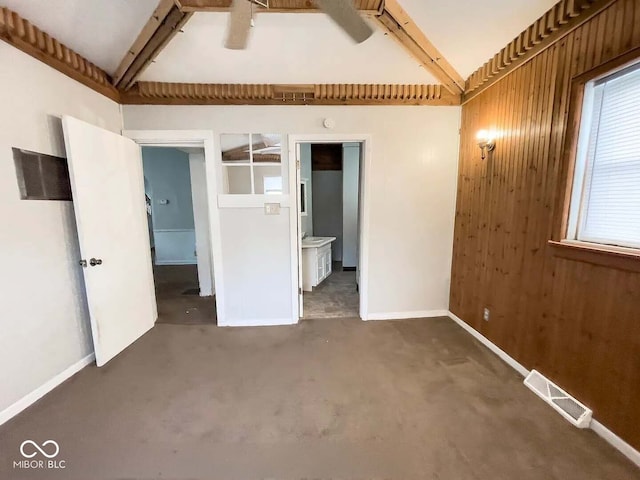 unfurnished bedroom with connected bathroom and wooden walls