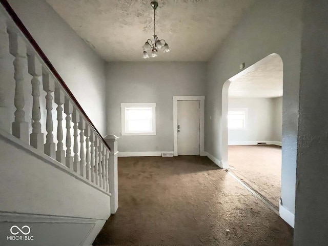 entrance foyer featuring carpet floors and a notable chandelier