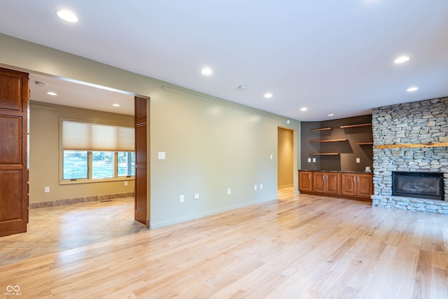 unfurnished living room featuring light wood-type flooring and a fireplace