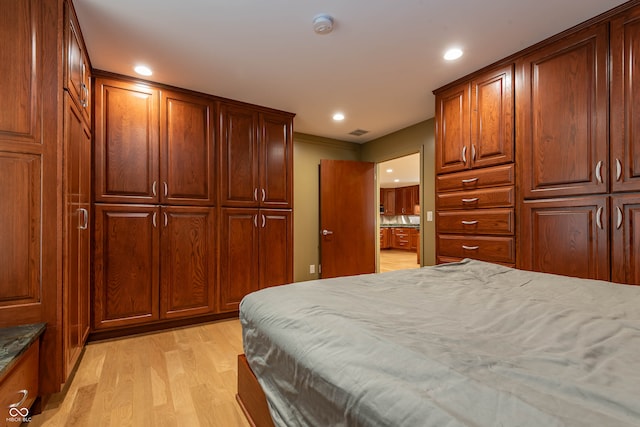 bedroom with ornamental molding, light hardwood / wood-style flooring, and a closet