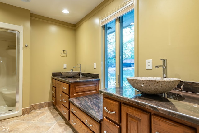 bathroom featuring ornamental molding, tile patterned floors, a shower with shower door, and vanity