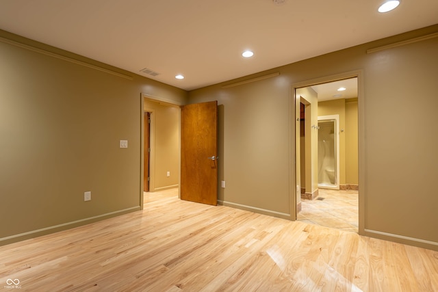 spare room with light hardwood / wood-style flooring and crown molding