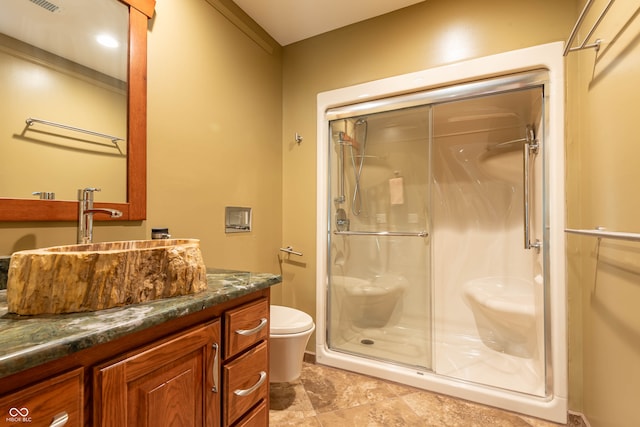 bathroom featuring vanity, toilet, and a shower with door