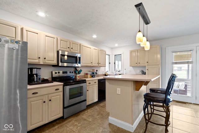 603 Ophelia Dr, Avon, IN 46123 - kitchen featuring appliances with stainless steel finishes, healthy amount of natural light, light countertops, a kitchen breakfast bar, and recessed lighting