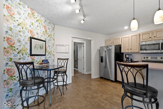603 Ophelia Dr, Avon, IN 46123 - kitchen featuring stainless steel appliances, light brown cabinetry, hanging light fixtures, a textured ceiling, and light countertops