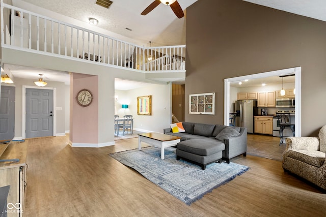 603 Ophelia Dr, Avon, IN 46123 - living room with high vaulted ceiling, a ceiling fan, baseboards, and light wood-style flooring