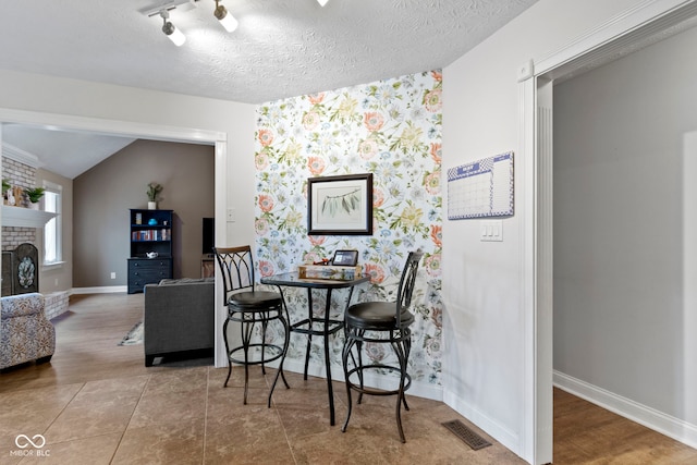 603 Ophelia Dr, Avon, IN 46123 - dining room with a fireplace, baseboards, and vaulted ceiling