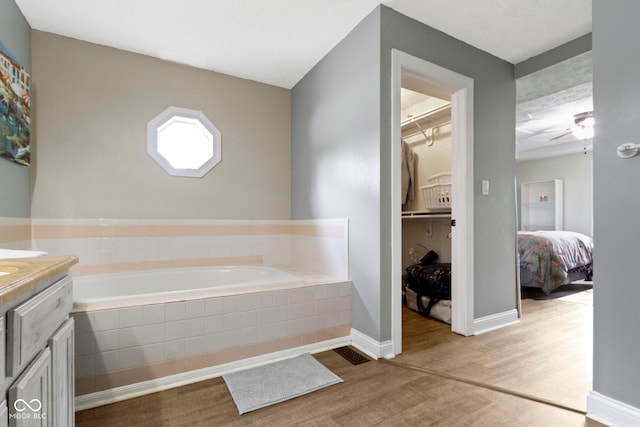 603 Ophelia Dr, Avon, IN 46123 - full bath with wood finished floors, a garden tub, vanity, a ceiling fan, and baseboards
