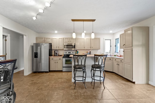 603 Ophelia Dr, Avon, IN 46123 - kitchen featuring stainless steel appliances, light countertops, hanging light fixtures, a breakfast bar area, and recessed lighting