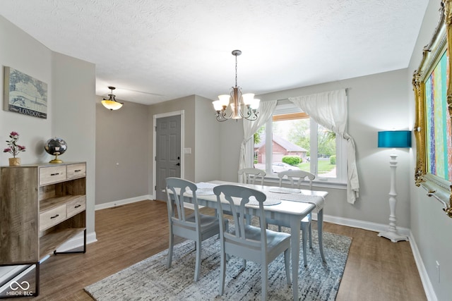 603 Ophelia Dr, Avon, IN 46123 - dining room with wood finished floors, a chandelier, baseboards, and a textured ceiling
