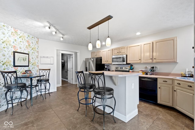 603 Ophelia Dr, Avon, IN 46123 - kitchen featuring stainless steel appliances, a kitchen bar, a kitchen island, light countertops, and light brown cabinets