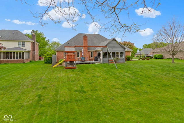 603 Ophelia Dr, Avon, IN 46123 - rear view of house with a deck, brick siding, a lawn, and a sunroom