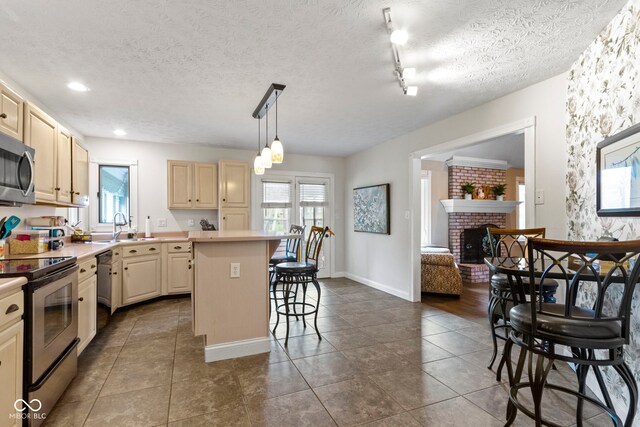 603 Ophelia Dr, Avon, IN 46123 - kitchen with appliances with stainless steel finishes, a sink, a kitchen breakfast bar, light countertops, and a center island