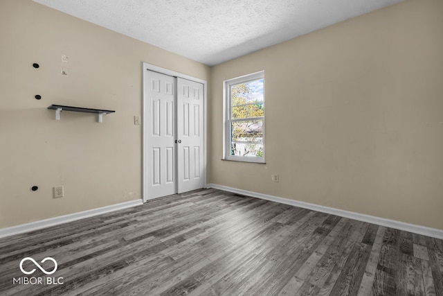 unfurnished bedroom featuring a closet, a textured ceiling, and hardwood / wood-style flooring