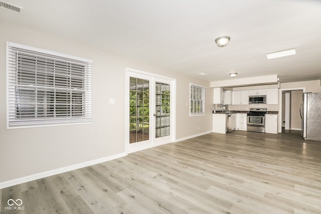 unfurnished living room with sink and light wood-type flooring