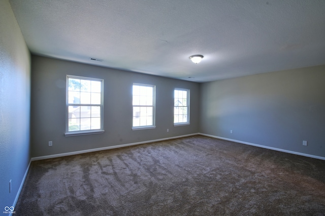 carpeted spare room with a textured ceiling